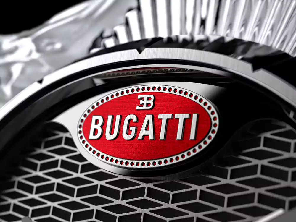 Close-up of the red Bugatti Macaron logo on the grille of the Calandre table clock