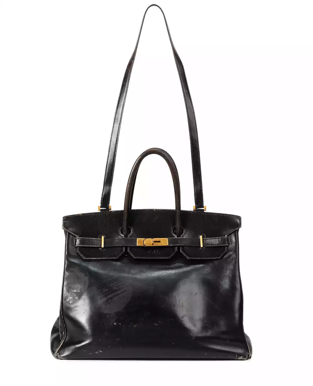 A full-length view of the well-worn 1985 Hermès Birkin, showing the unique non-removable shoulder strap and signs of use.