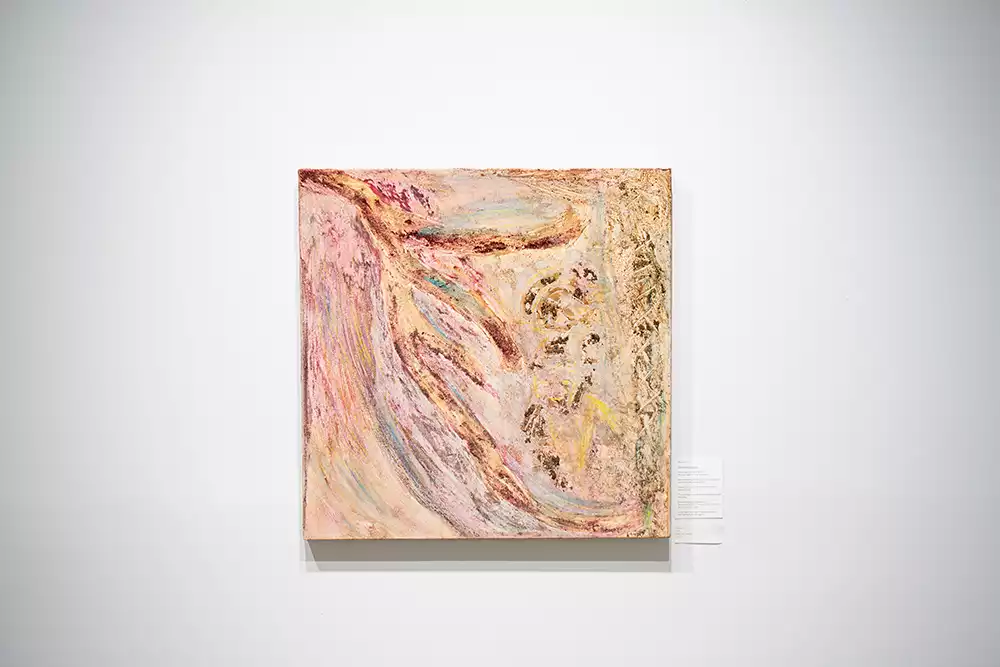 The abstract painting "Innocence" by Kasia Muzyka on a white wall, featuring swirling, heavily textured forms in shades of pink, cream, and brown.