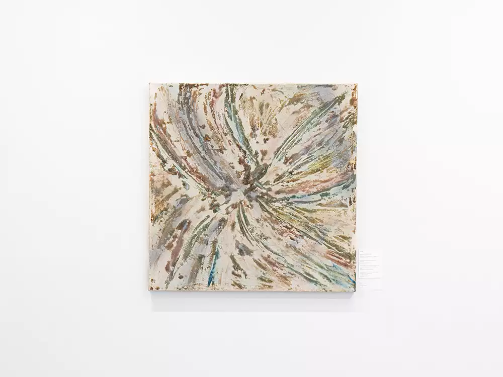 A square abstract painting titled "Zero" by Kasia Muzyka on a white wall, depicting a central, starburst-like form with radiating textured lines