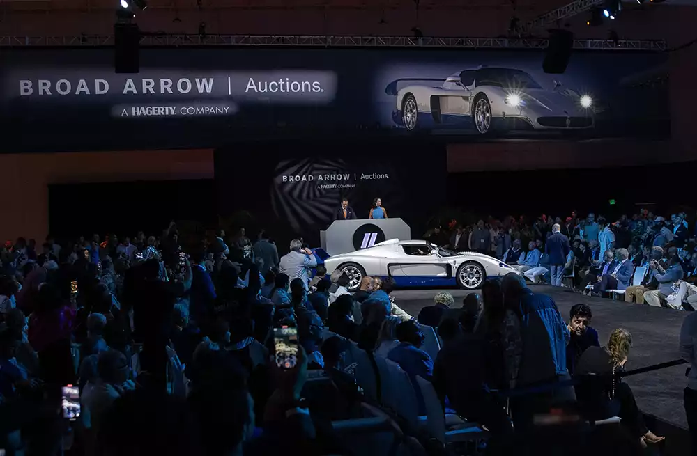 The Maserati MC12 Stradale surrounded by bidders on the auction floor at Monterey Car Week