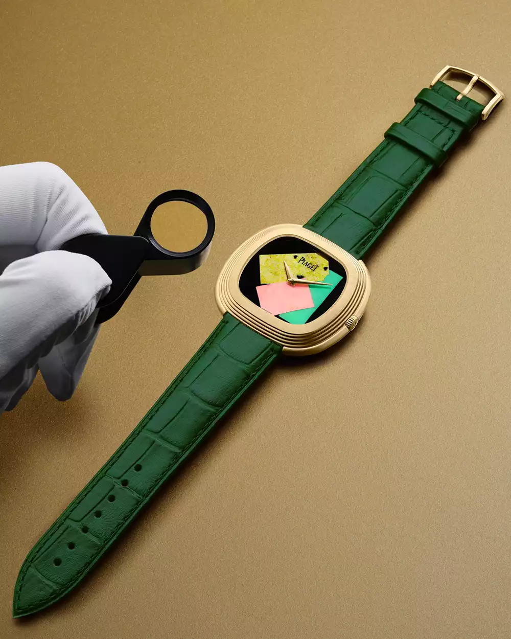 A watchmaker inspecting the stone dial of the Piaget Andy Warhol Collage watch with a loupe