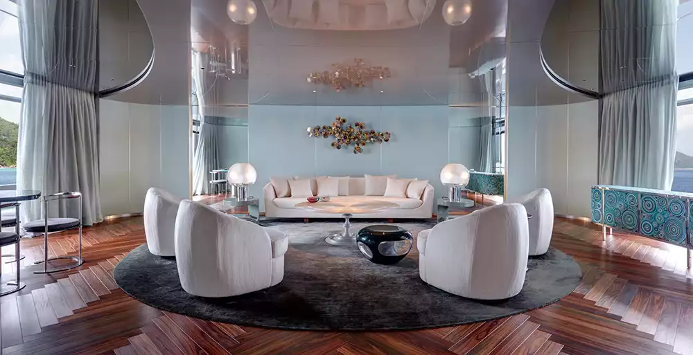 Guest lounge aboard the Savannah yacht featuring dark rosewood floors and modern white furniture