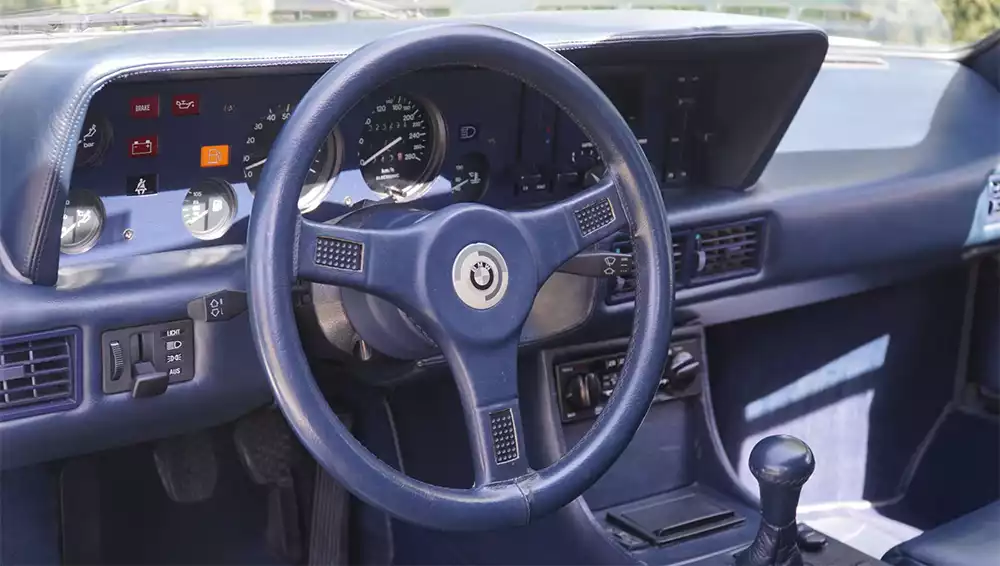 Dashboard and steering wheel of Niki Lauda's BMW M1 showing the manual transmission stick shift
