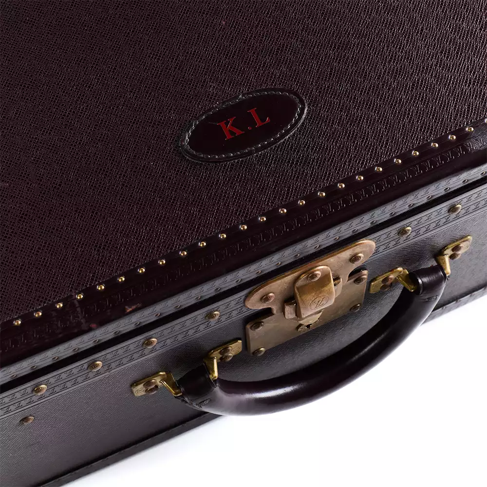 Close-up of the elegant dark brown Louis Vuitton Breakfast Cabine exterior, featuring a brass lock, leather handle, and the "K.L." monogram