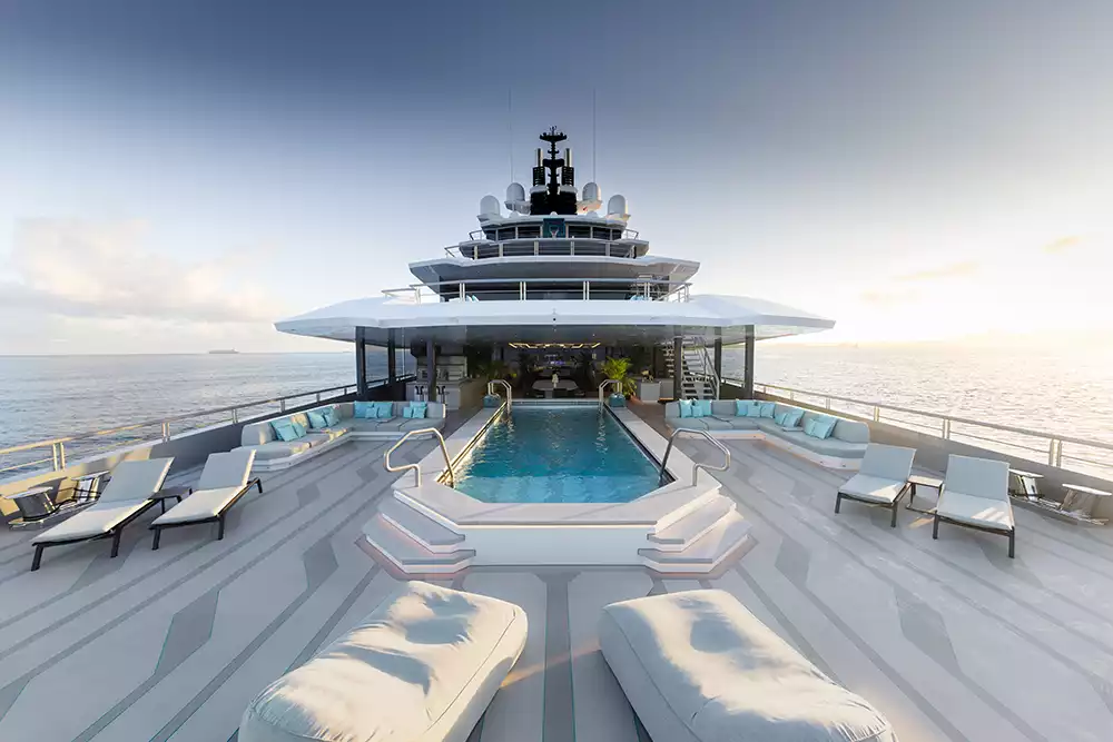 Luxurious aft deck swimming pool and lounging area on the Oceanco Leviathan yacht