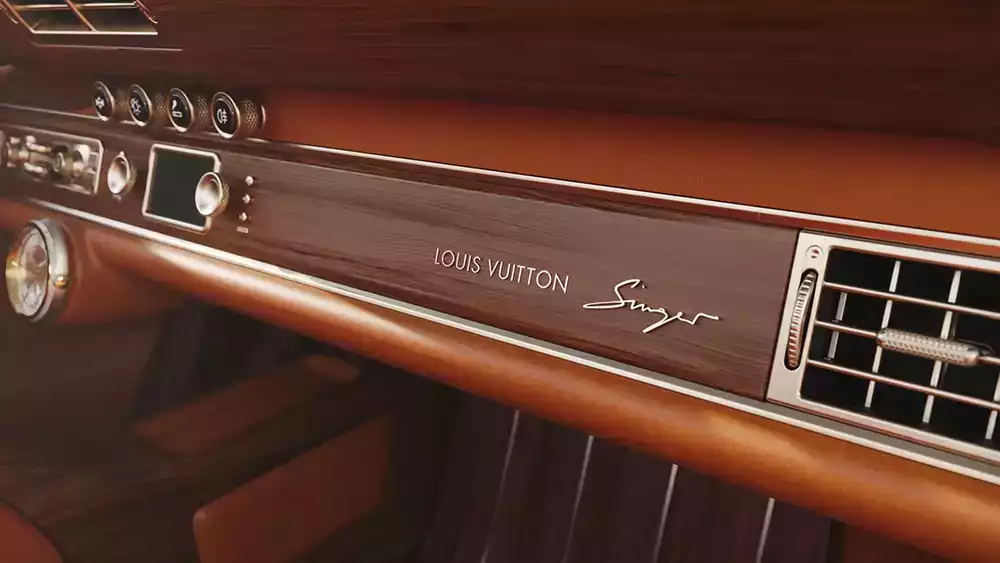 Close-up of the precious wood-trimmed dashboard with the Louis Vuitton and Singer script branding
